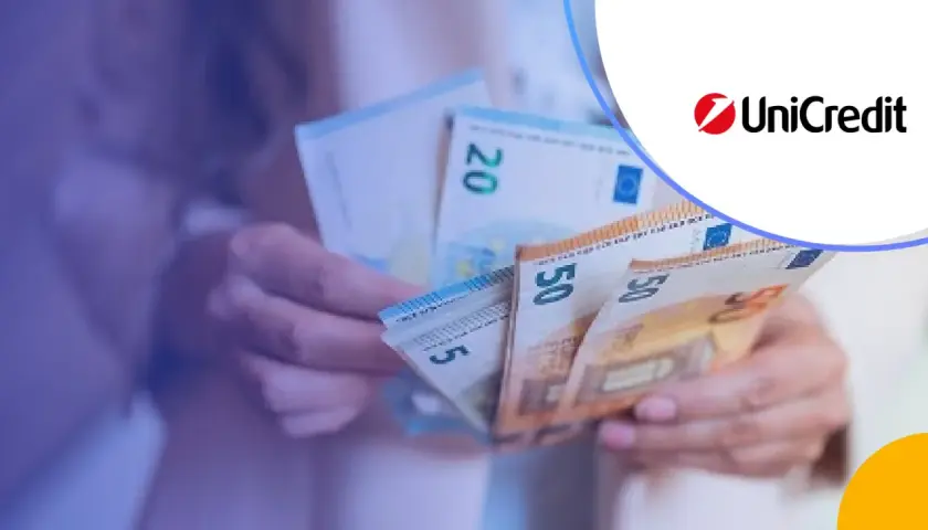 Dłonie trzymają banknoty euro, w tym 50 i 20 euro. Logo UniCredit sugeruje usługi bankowe.