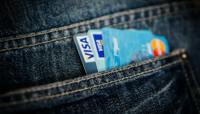 Dwie karty Visa i karta Paypass schowane w kieszeni jeansów. Wygodna karta prepaid na codzienne zakupy.
