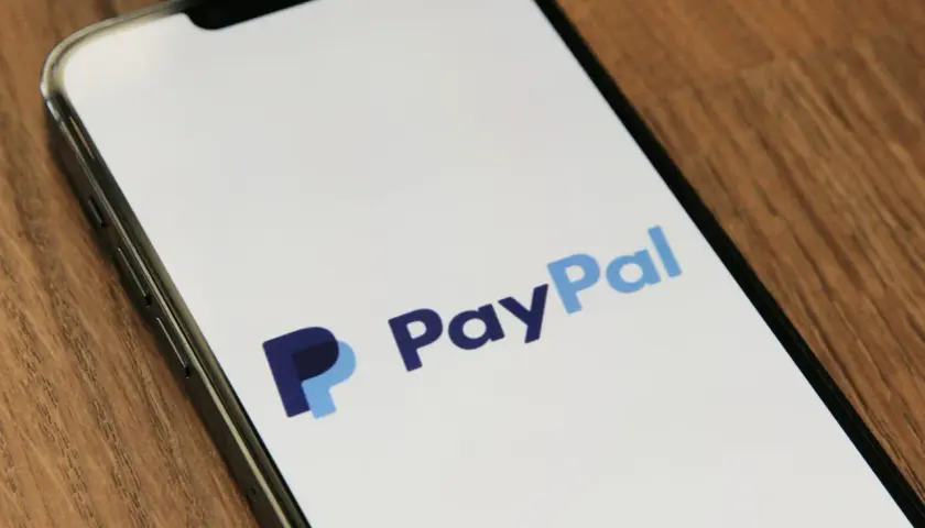 Ekran telefonu z logo PayPal. Czy PayPal jest bezpieczny? Tak, to popularna i bezpieczna metoda płatności online.