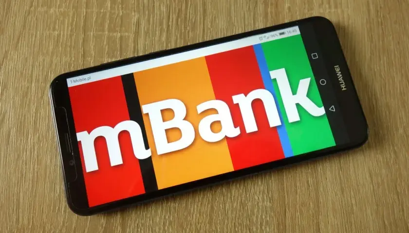 Smartfon z logo mBank na ekranie. Dowiedz się, jak aktywować kartę w aplikacji bankowej.