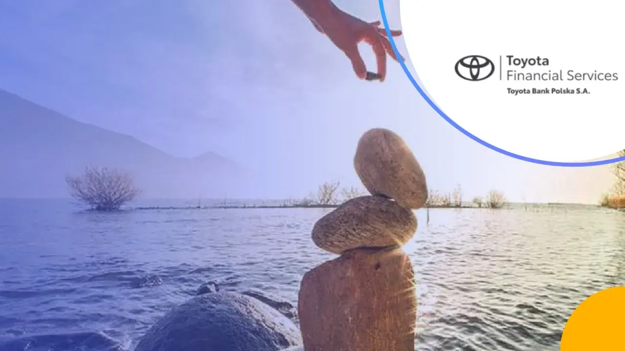 Równowaga jak w toyota bank lokaty. Ręka układa kamienie nad jeziorem.