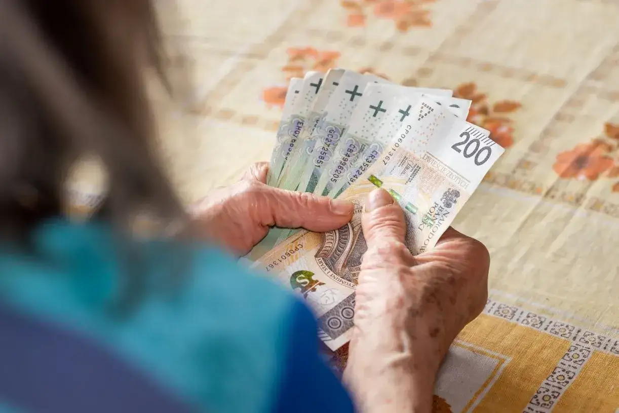 Dłonie liczą banknoty 200 zł. Może to być wypłata z konta Aurum, która pozwoli na spokojne życie.